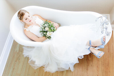 A bride sits in the tub in the Acre 31 bridal suite.