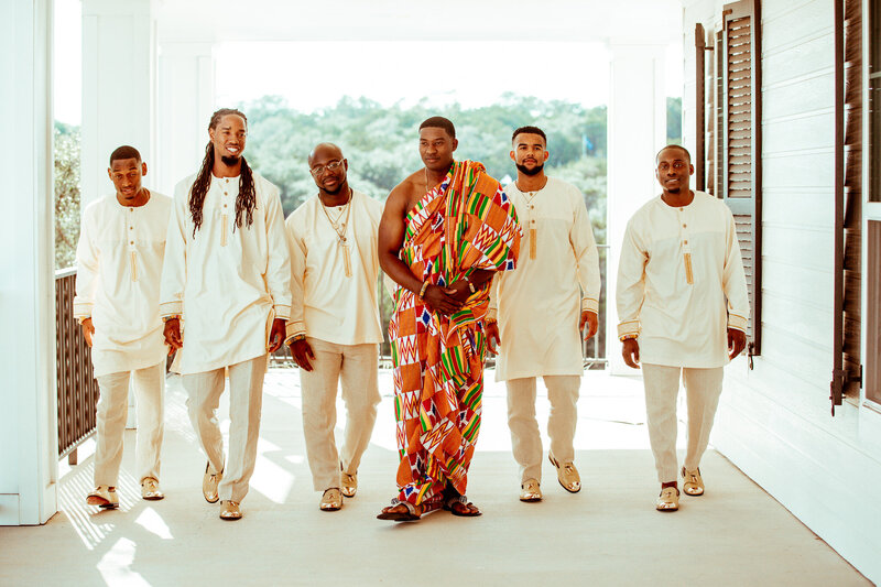 A groom and his groomsmen pose on the Acre 31 balcony