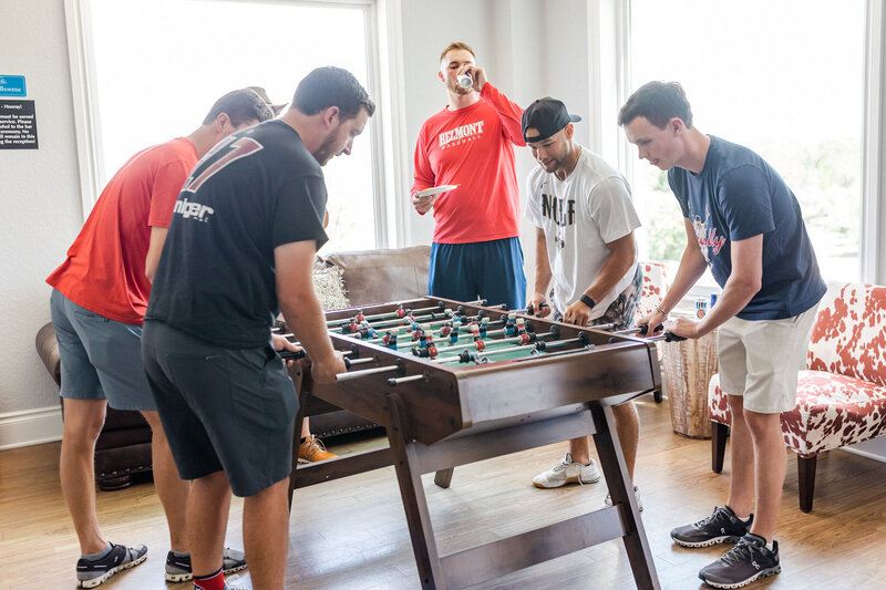 Groom and his groomsmen playing foosball in the groom's suite.